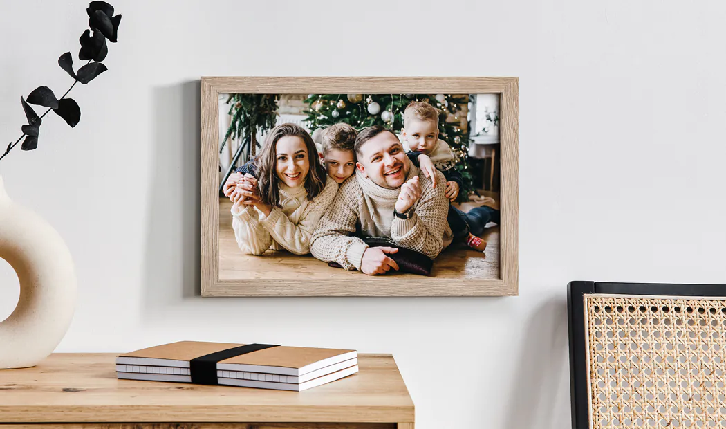 Personalised family Christmas framed print: happy family of four by the tree. Warm, festive feel.