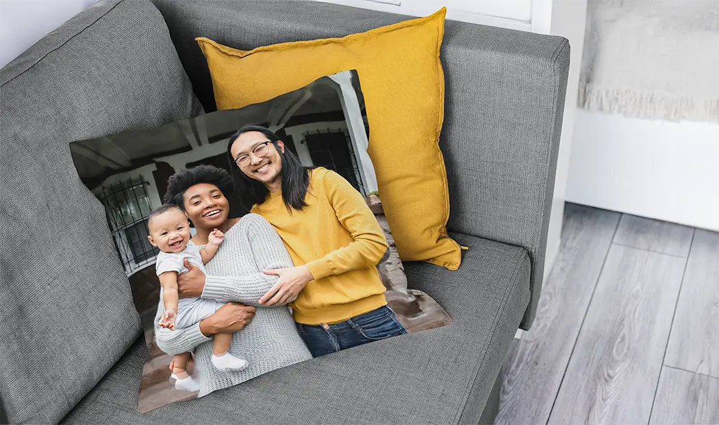 Personalised cushion featuring a happy family photo, placed on a sofa. Create a unique keepsake!